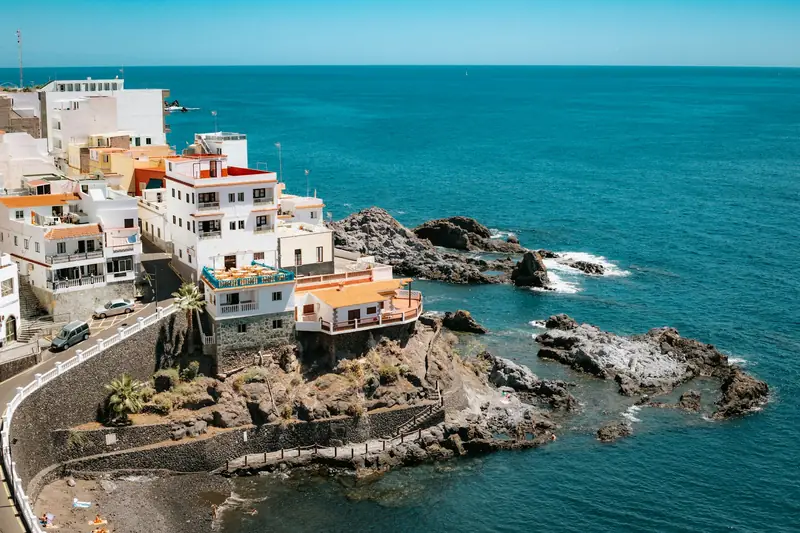 Casas blancas sobre las rocas volcánicas frente al mar azul en Los Gigantes