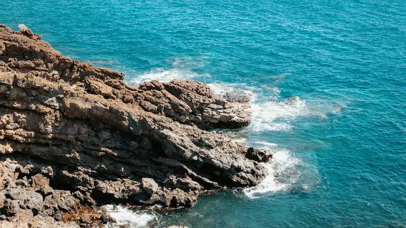 Rocas volcánicas negras y mar turquesa en la costa de Los Gigantes